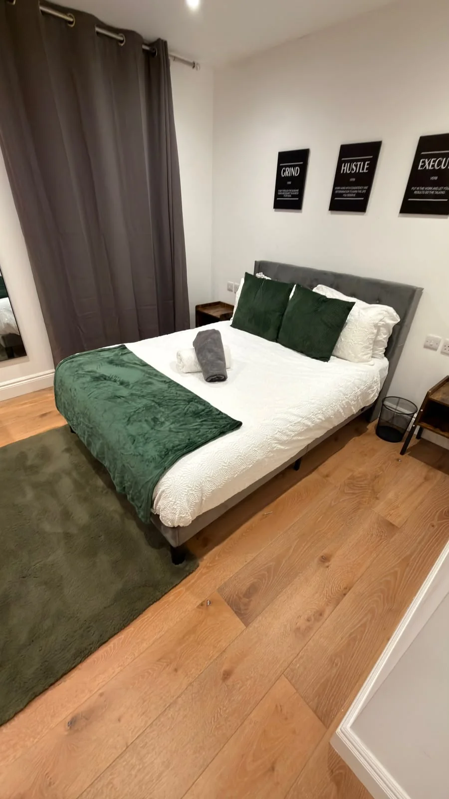 Prepared bedroom with green bed runner and folded towels