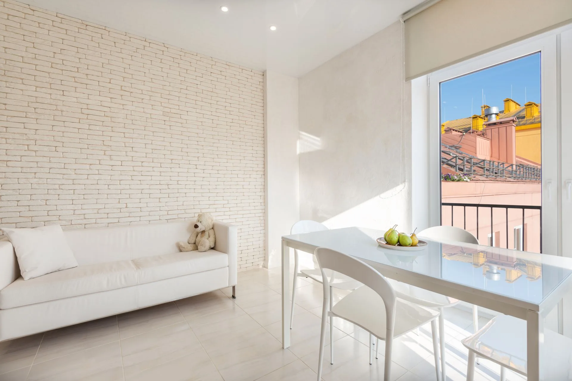 Decorative stock interior: sunlit living room with white sofa and dining table, not an Elite Cleans job
